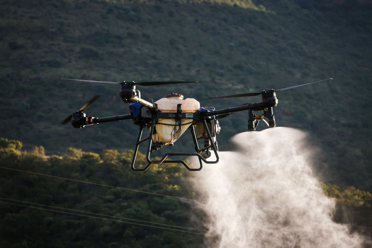 Aerial view of a drone spraying crops with precision agriculture technology.